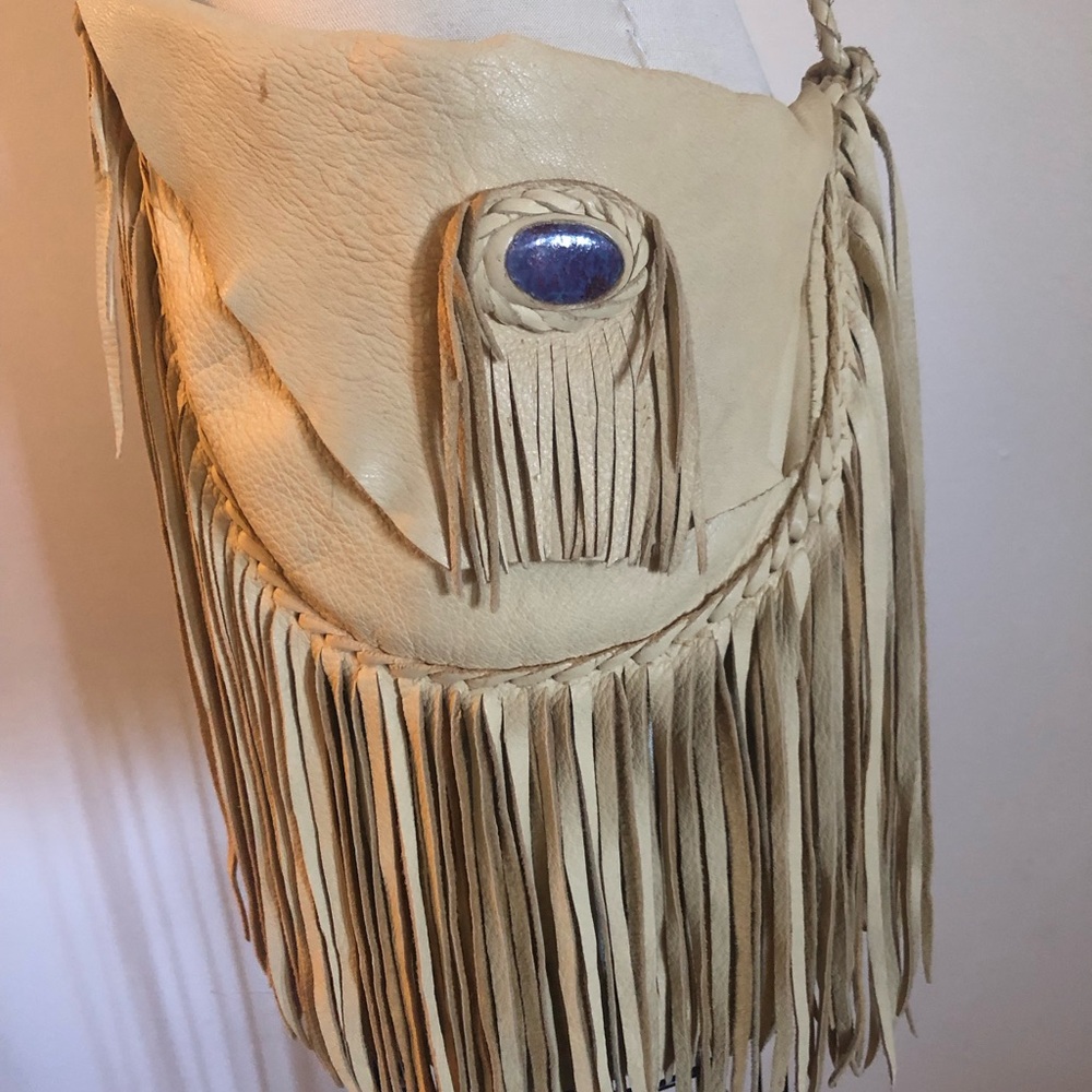 Buffalo leather purse with fringe and stone detail.